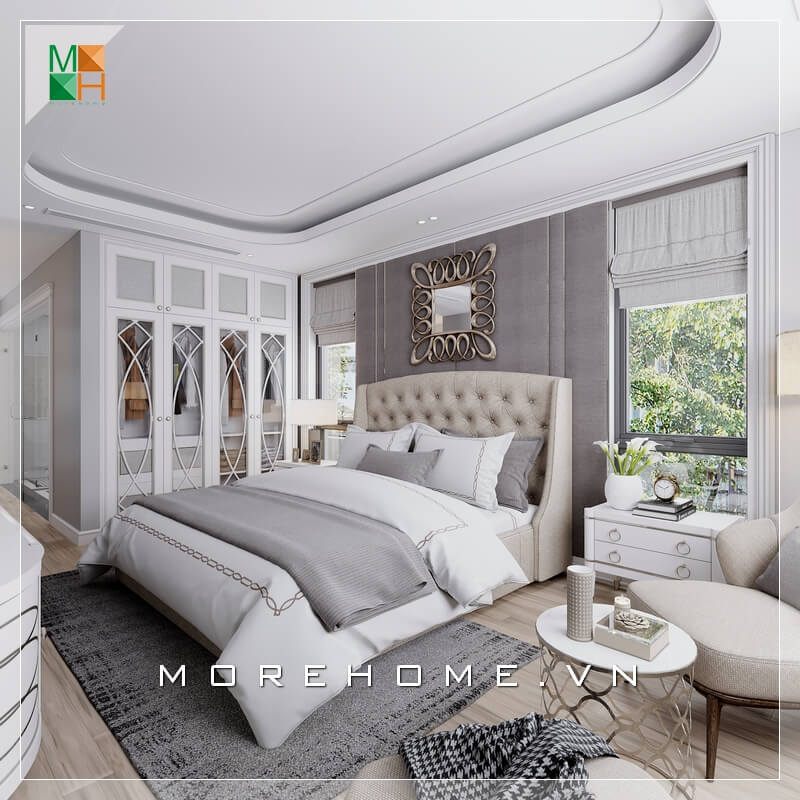 Mẫu thiết kế giường ngủ phong cách tân cổ điển được bọc nệm đầu giường tạo sự êm ái khi tựa lưng. Nệm ốp tường bọc nỉ đem lại nét quyến rũ cho căn phòng. Hệ tủ âm tường kịch trần kết hợp ghế thư giãn cùng tông tạo sự liền mạch trong không gian bố trí nội thất.